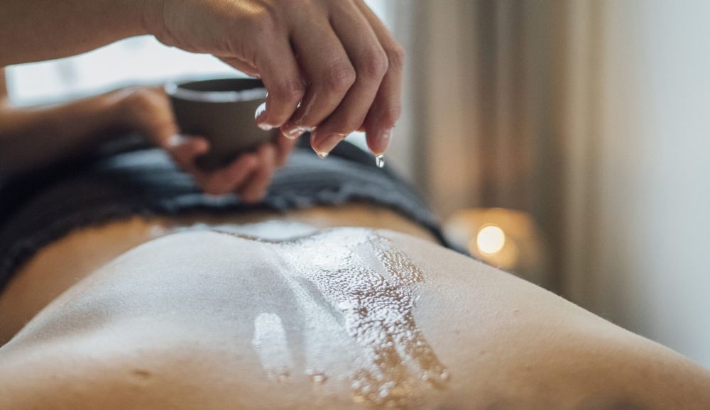 Mann geniesst eine entspannende Rückenmassage bei der AMAYA AG, Kosmetik in Aarau und Lenzburg